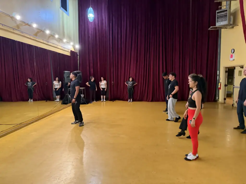 Salsa instructor leading dancers in a mirrored dance studio