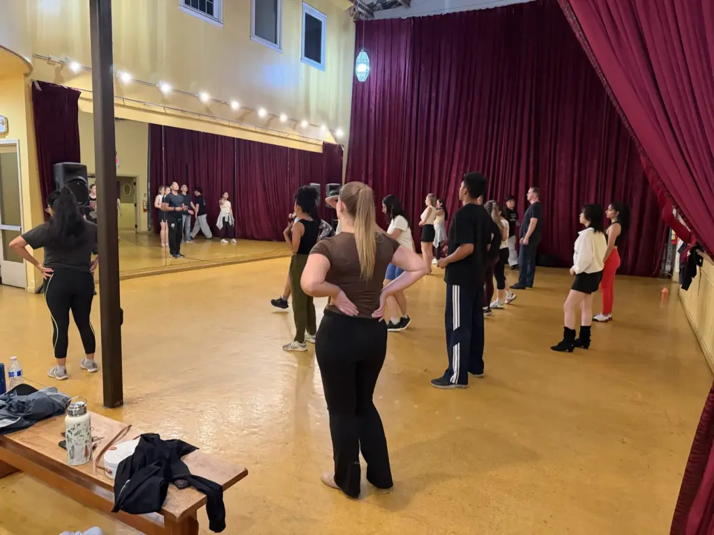 Workshop participants practicing salsa steps in the dance studio